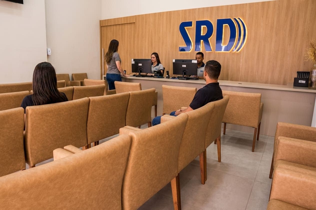 Recepção da SRD Clínica, com a equipe atendendo pacientes no balcão